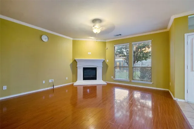 a view of an empty room with a fireplace and a window