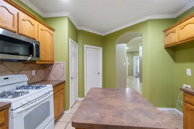 a view of a kitchen with fridge and wooden floor