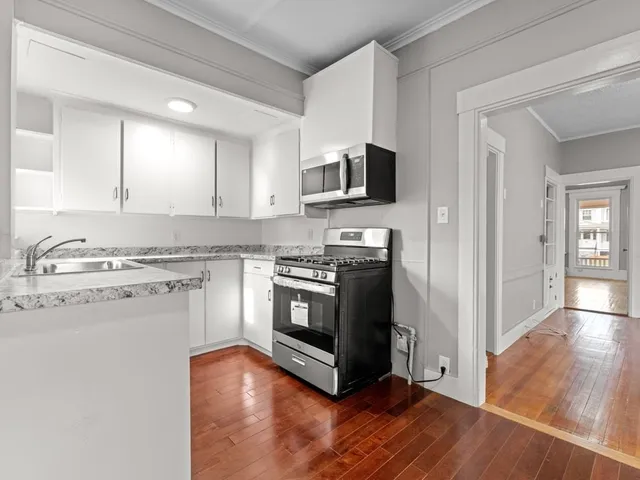 a kitchen with stainless steel appliances granite countertop a stove top oven a sink and a microwave