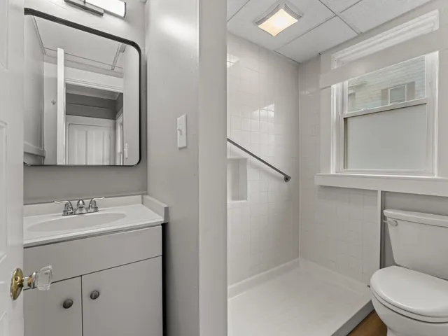 a bathroom with a toilet sink and mirror