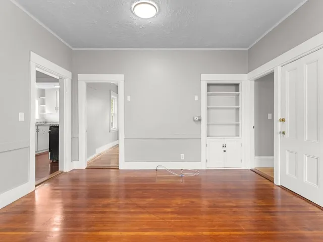 a view of empty room with wooden floor