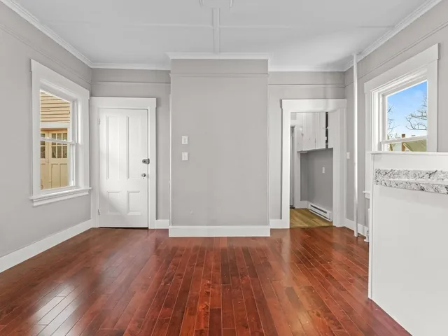 a view of a big room with wooden floor and windows