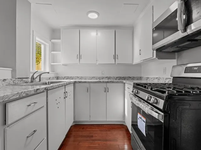 a kitchen with granite countertop cabinets stainless steel appliances and a sink