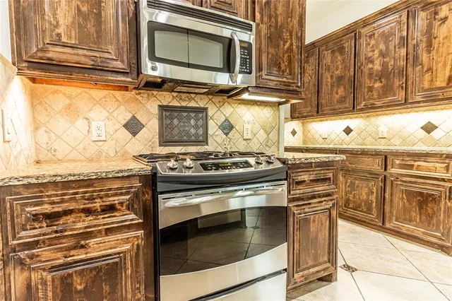 a kitchen with stainless steel appliances granite countertop a stove and a microwave