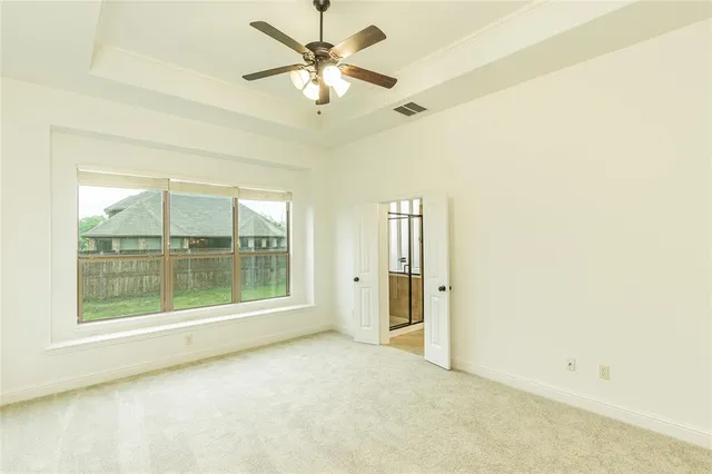 an empty room with a large window with a fan