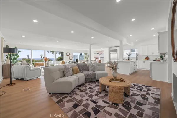 a living room with furniture a fireplace and a view of kitchen