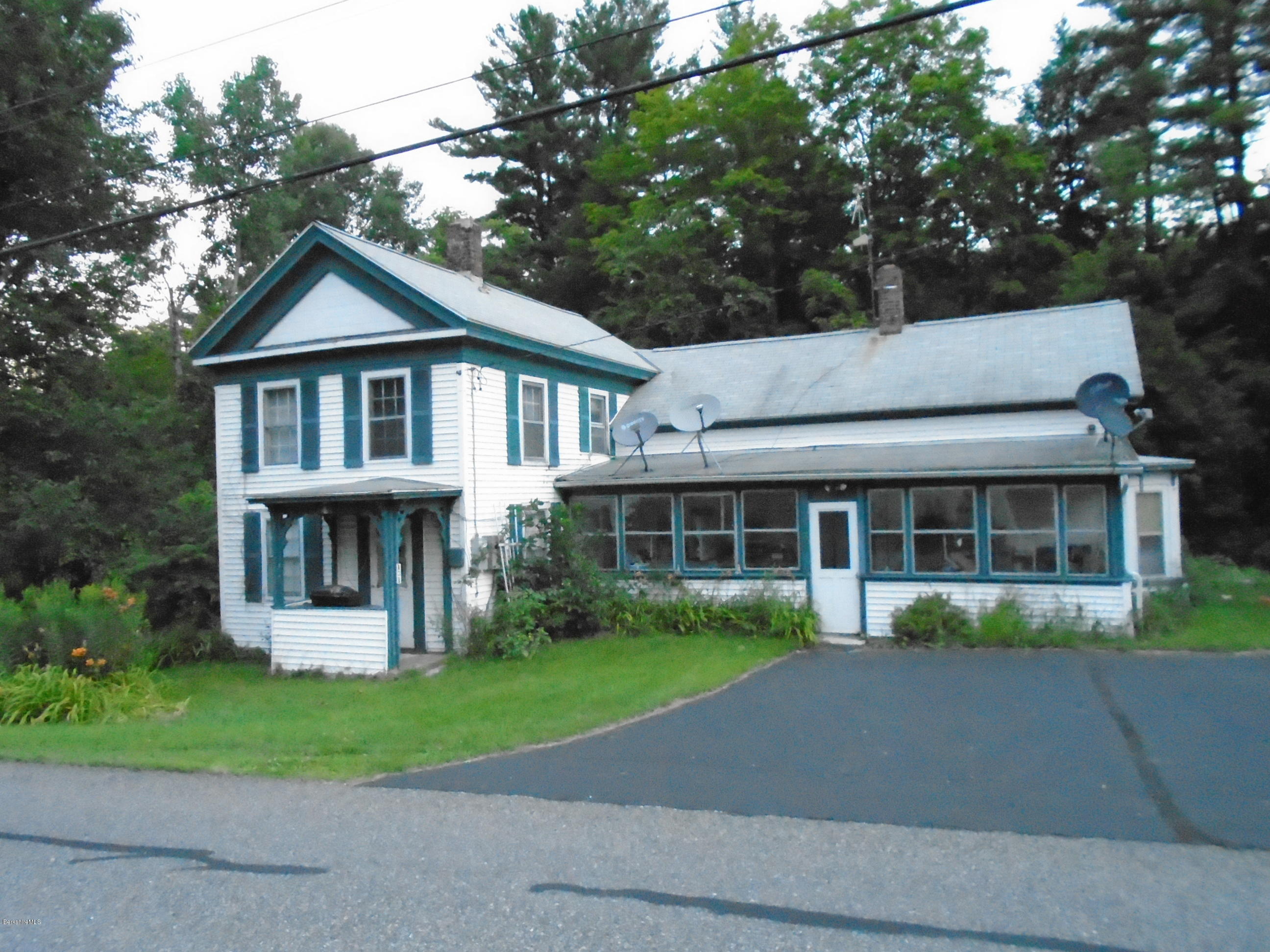 131 Main Road Tyringham, MA 01264 - Photo 1 of 5 a front view of a house with a garden and trees