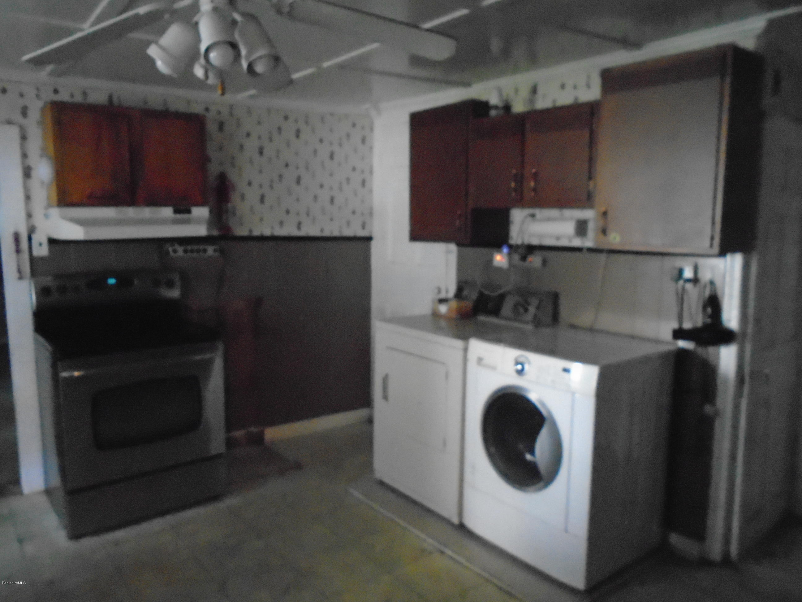 131 Main Road Tyringham, MA 01264 - Photo 3 of 5 a kitchen with a stove top oven and cabinets