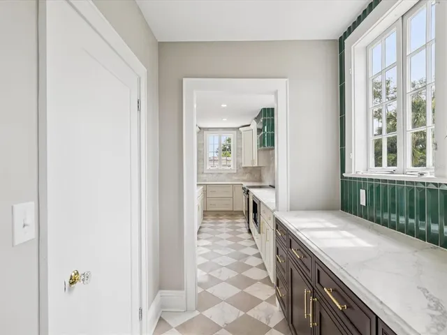 a view of hallway with window and wooden floor