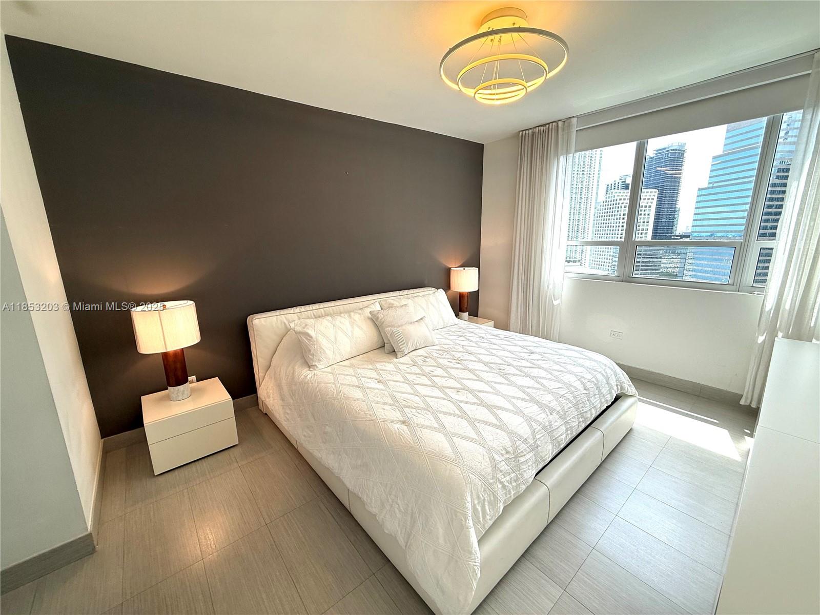 801 Brickell Key Boulevard, Unit 2402 Miami, FL 33131 - Photo 11 of 37 a large bed sitting in a bedroom next to a window