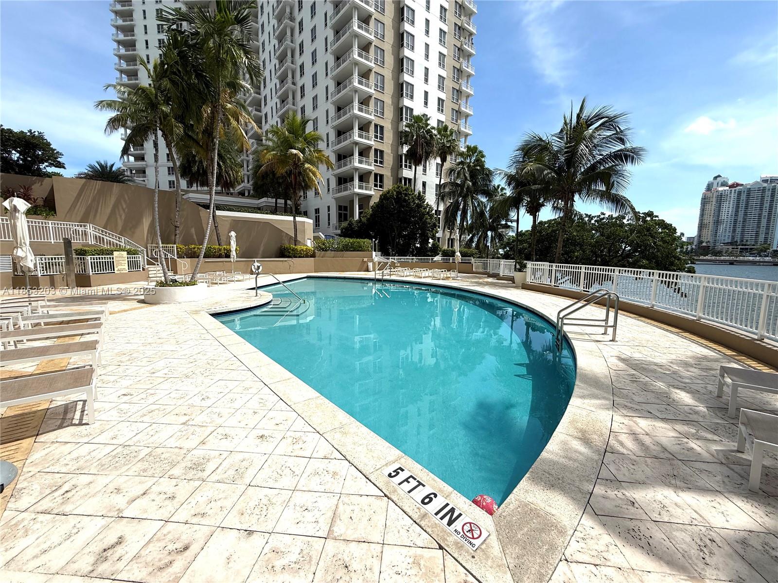 801 Brickell Key Boulevard, Unit 2402 Miami, FL 33131 - Photo 31 of 37 a swimming pool with outdoor seating and yard