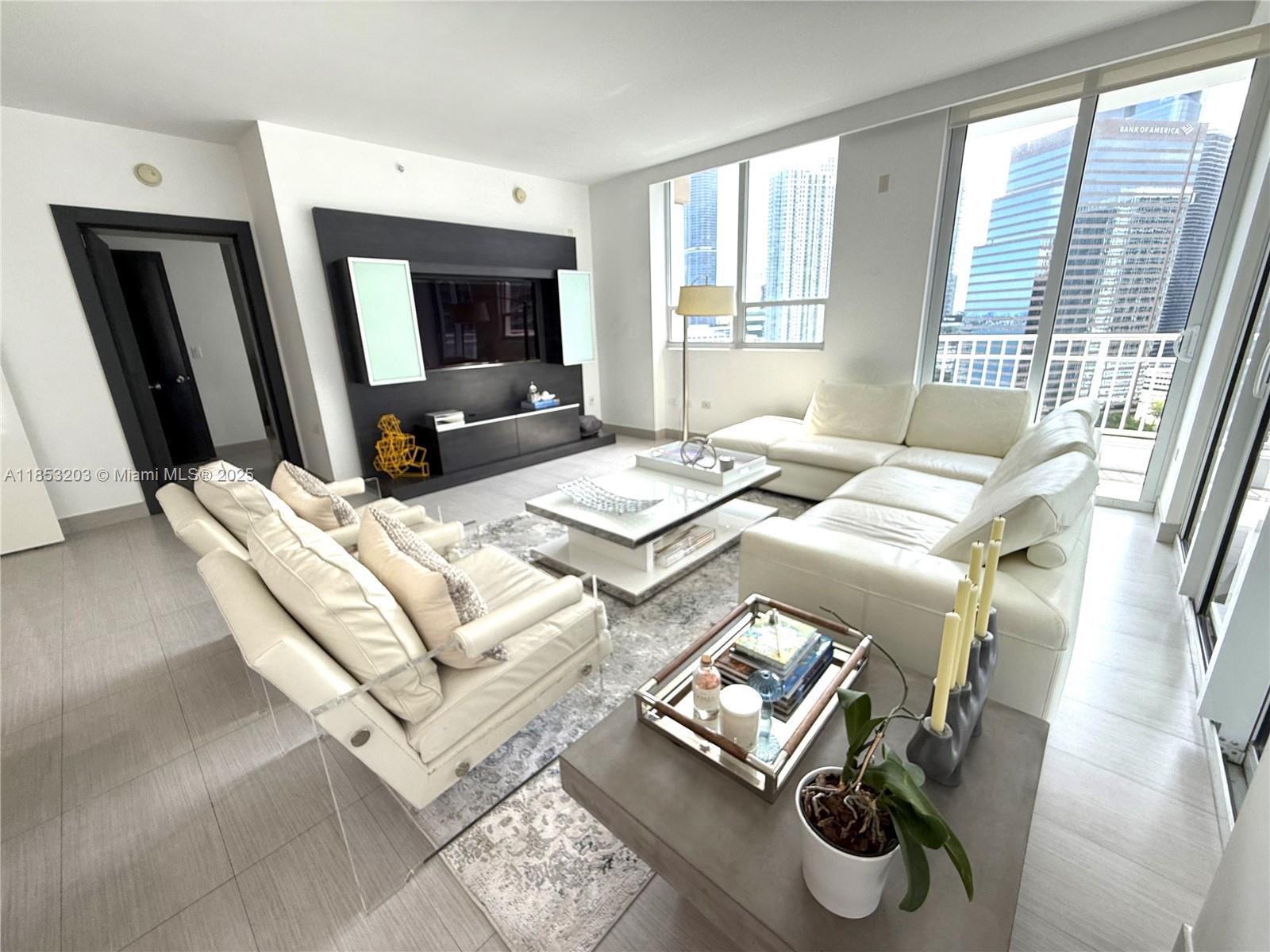 801 Brickell Key Boulevard, Unit 2402 Miami, FL 33131 - Photo 4 of 37 a living room with furniture and a flat screen tv