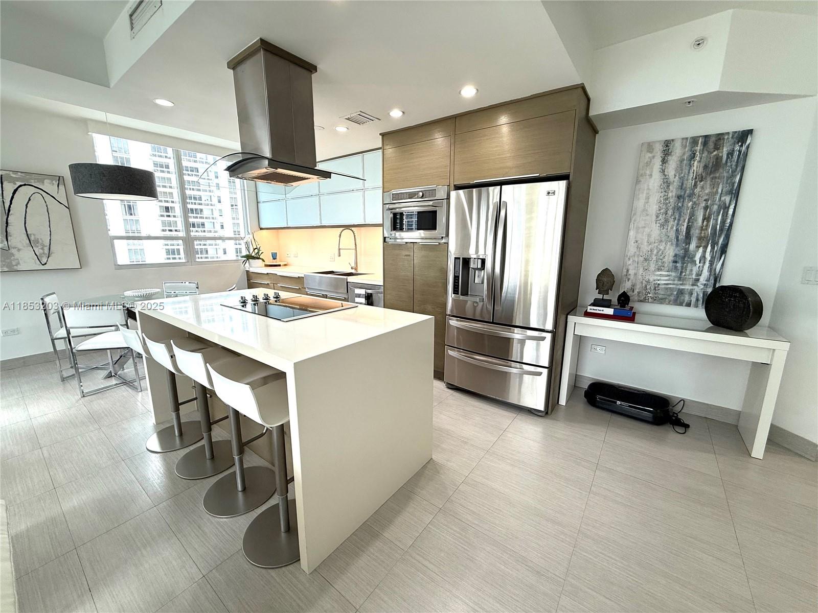 801 Brickell Key Boulevard, Unit 2402 Miami, FL 33131 - Photo 7 of 37 a kitchen with stainless steel appliances kitchen island granite countertop a sink stove and refrigerator