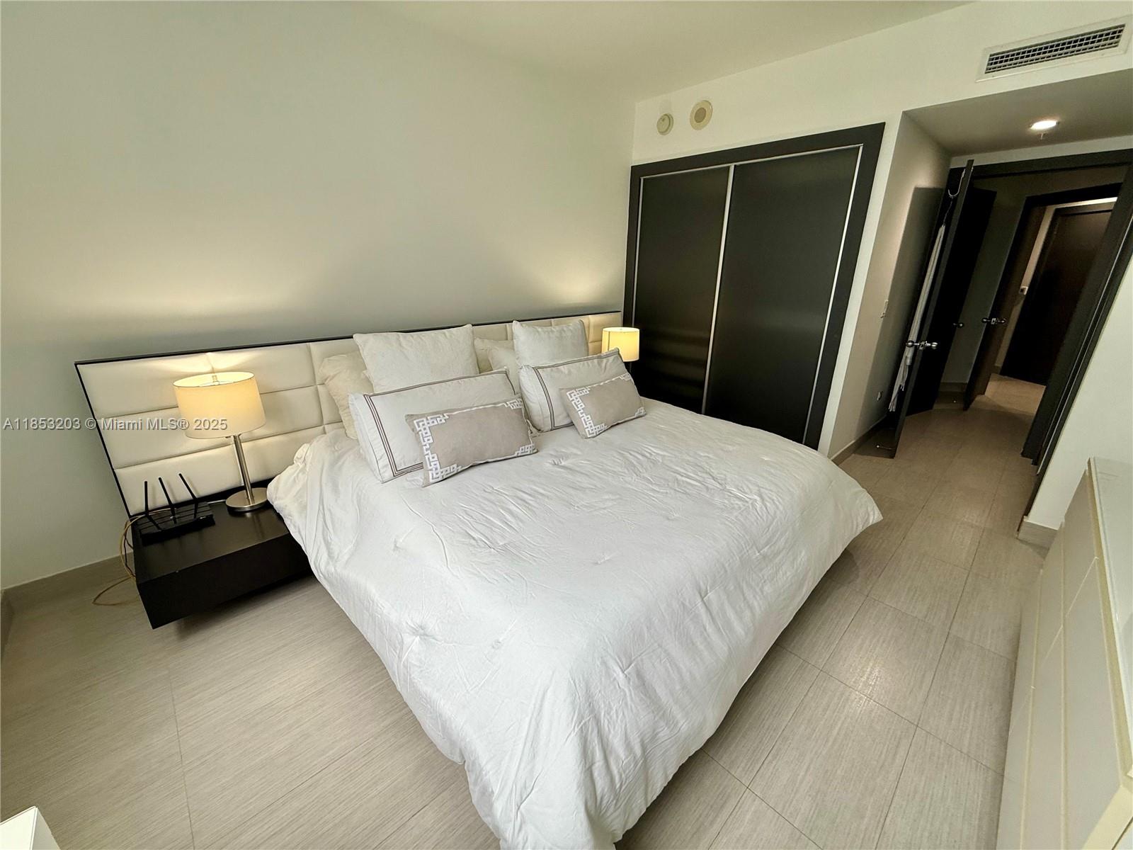 801 Brickell Key Boulevard, Unit 2402 Miami, FL 33131 - Photo 9 of 37 a bed room with a bed and a television