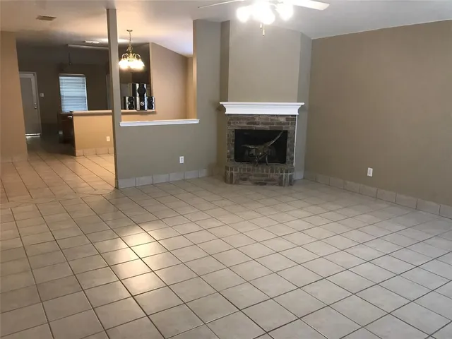 an empty room with fireplace and mirror