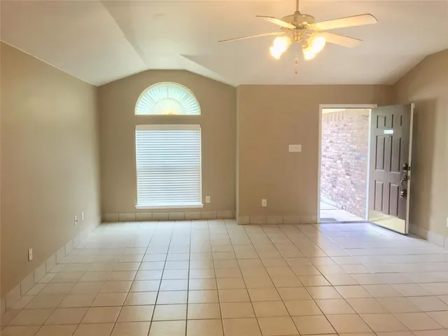 an empty room with fan and windows