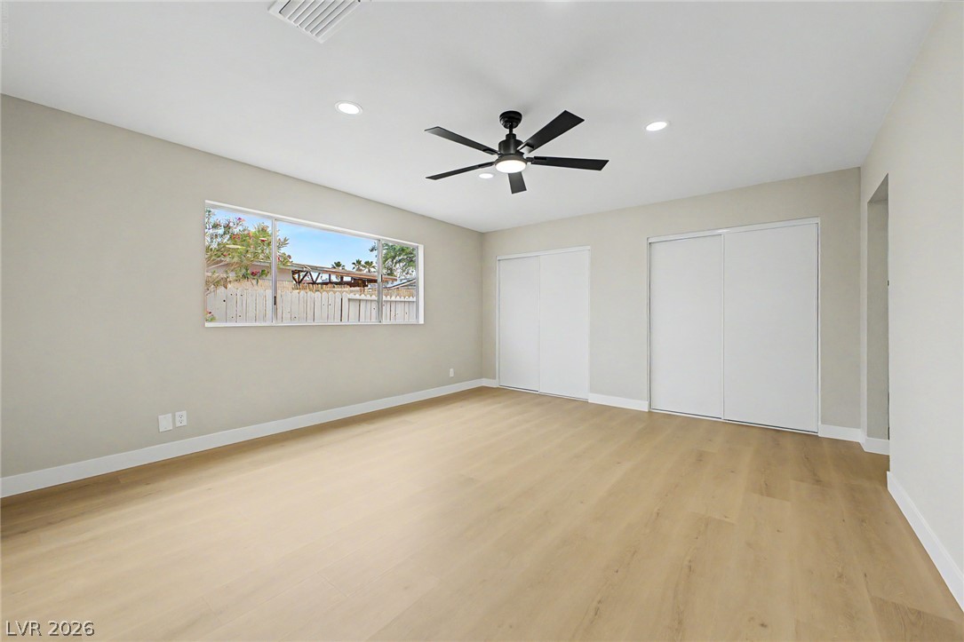 324 Lakehurst Road Las Vegas, NV 89145 - Photo 10 of 30 Smooth wood-look flooring and recessed lighting define this spacious bedroom area.