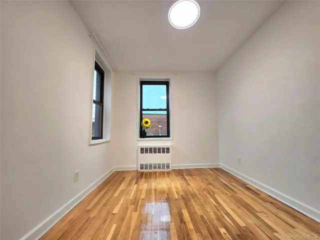 a view of a room with wooden floor and window