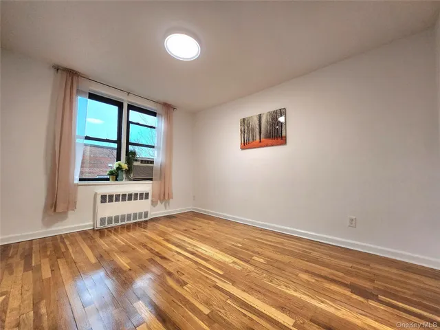 a view of a room with wooden floor and window
