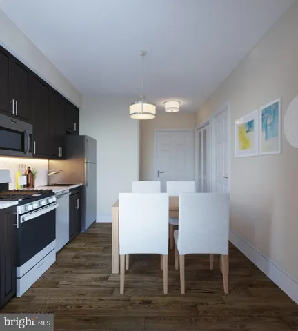a kitchen with granite countertop a table chairs microwave and cabinets