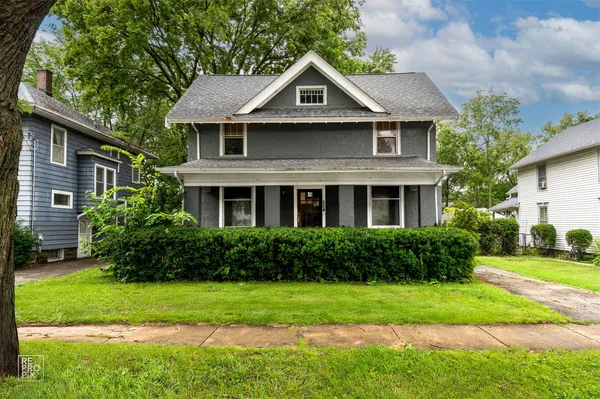 a front view of a house with a yard and trees