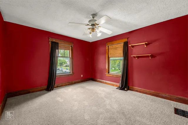 an empty room with windows and closet