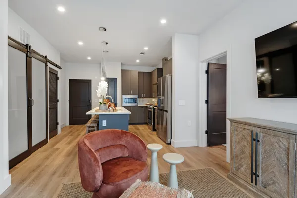 a large kitchen with stainless steel appliances kitchen island granite countertop a refrigerator and a sink