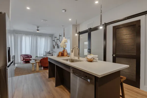 a kitchen with a sink appliances and wooden floor