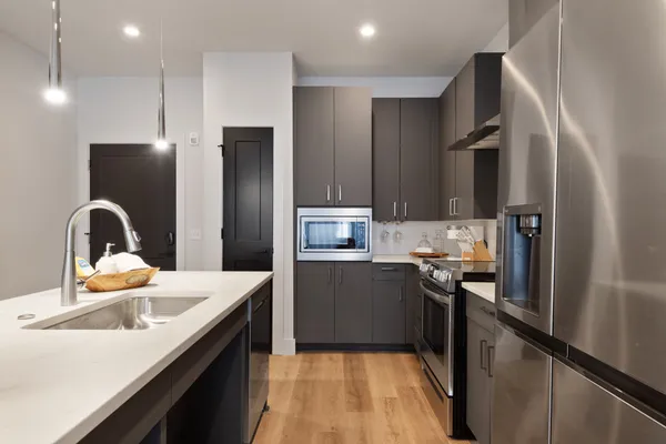 a kitchen with stainless steel appliances granite countertop a refrigerator and a sink