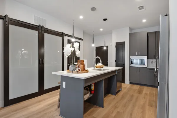 a kitchen with stainless steel appliances granite countertop a refrigerator a sink dishwasher and a refrigerator with wooden floor