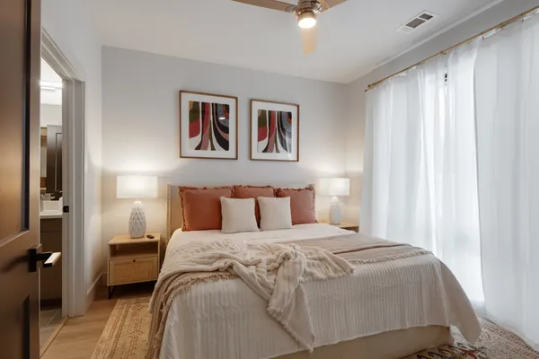 a bedroom with a large bed and a chandelier