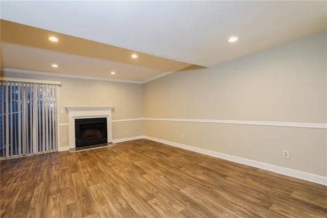 a view of empty room with wooden floor and fireplace