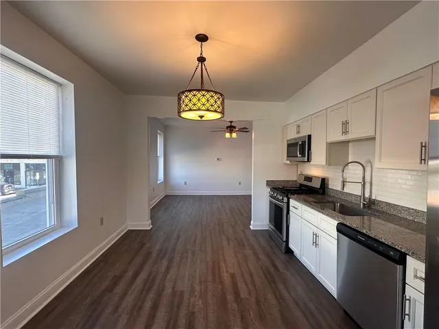 a kitchen with stainless steel appliances granite countertop a sink stove and refrigerator