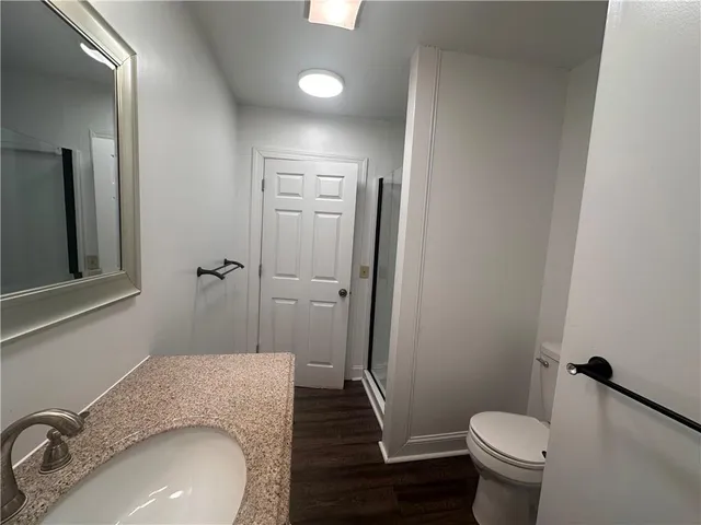 a bathroom with a granite countertop sink toilet and shower