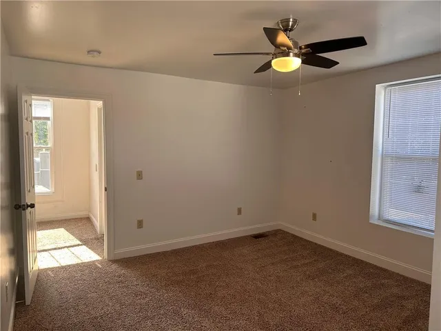 an empty room with closet and windows