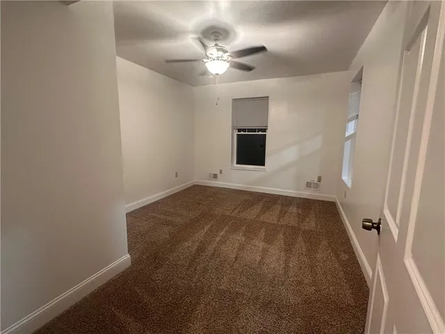 wooden floor in an empty room with a ceiling fan