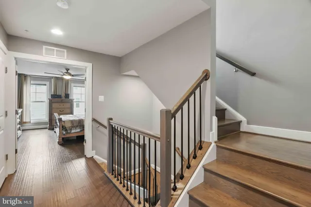 a view of a hallway with wooden floor and stairs