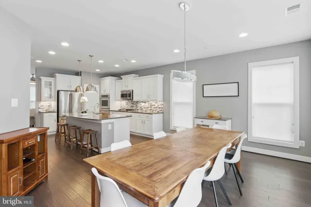 a kitchen with a table chairs refrigerator and microwave