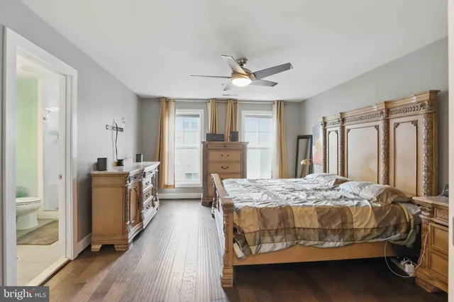 a bedroom with a bed dresser and wooden floor