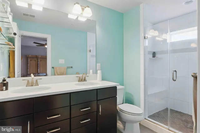 a bathroom with a sink a toilet a mirror and shower