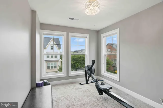 a view of a room with gym equipment and floor to ceiling window