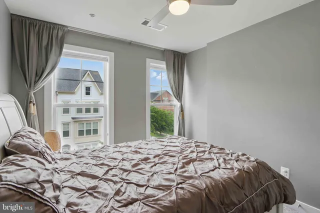 a bedroom with a bed and a large window