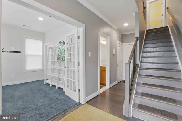 a view of a hallway with entryway and hall with wooden floor