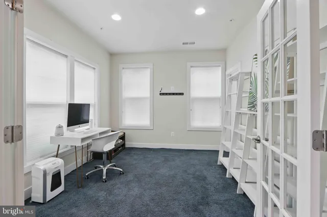 a view of a workspace with furniture and a window