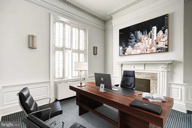 a view of a workspace with a fireplace and a window