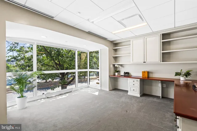 a large white kitchen with granite countertop a large window