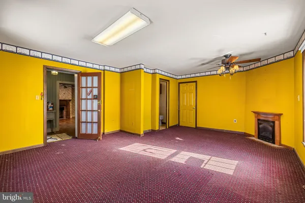 a view of an empty room with bathroom and a window