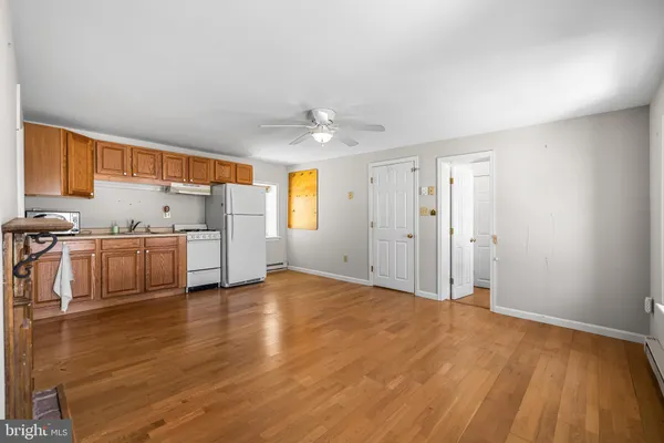 a view of a livingroom with furniture a ceiling fan and wooden floor
