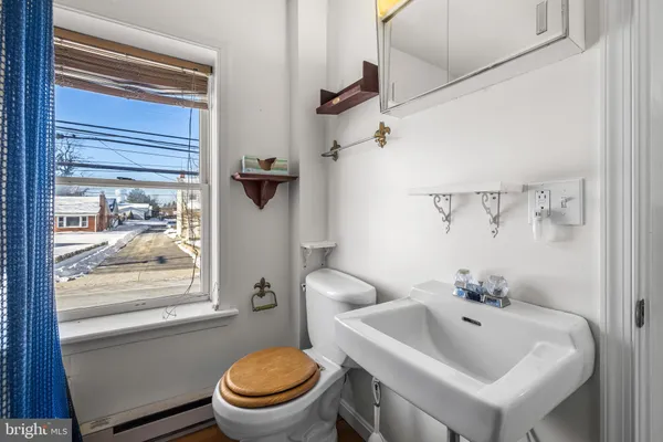 an empty room with wooden floor chandelier and windows