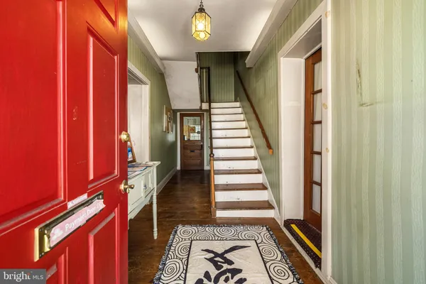 a view of a hallway with wooden floor and staircase